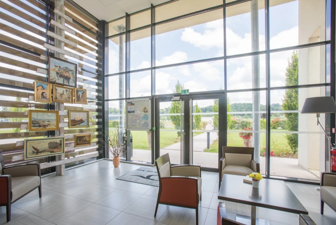 Hall vitré d’un bâtiment donnant sur un jardin