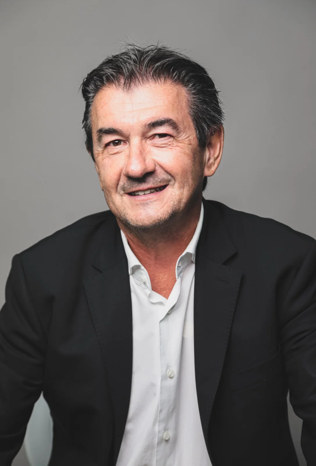 Portrait professionnel d’un homme souriant en veste sombre