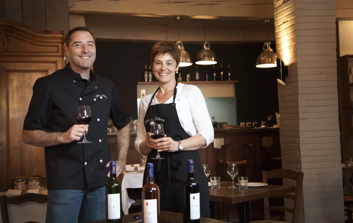 Deux professionnels dans un restaurant tenant des verres de vin