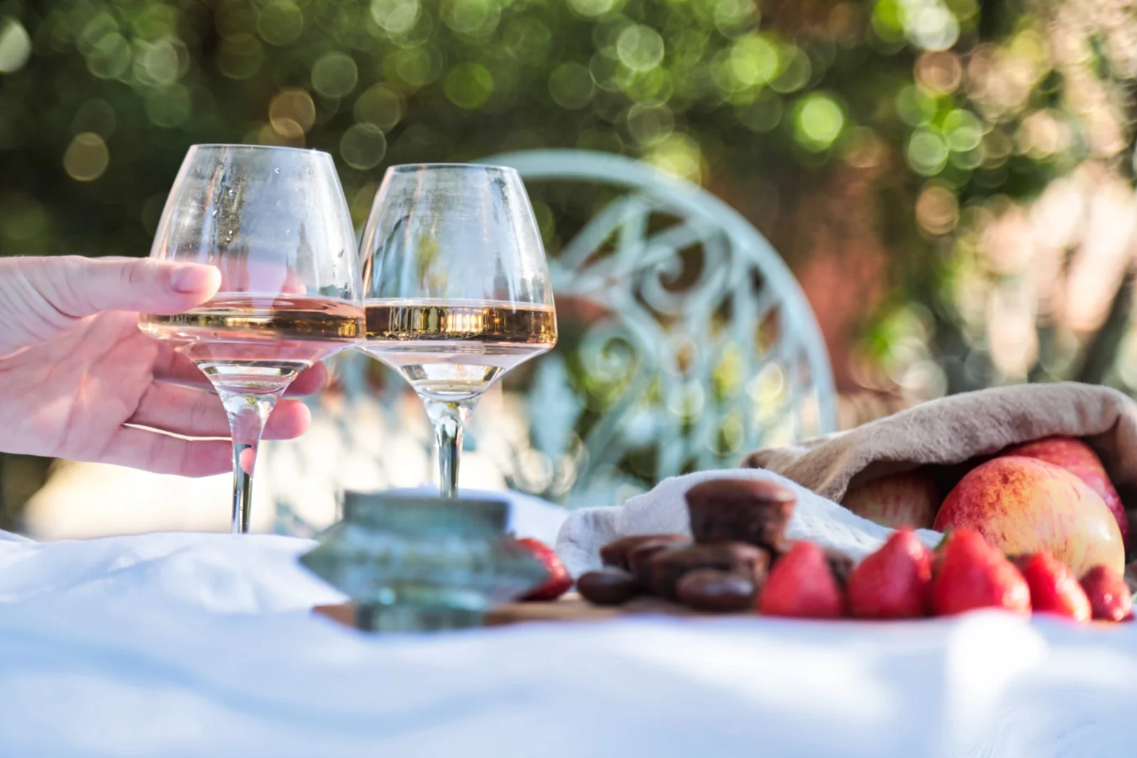 Deux verres de vin et des fruits photographiés sur une table en extérieur