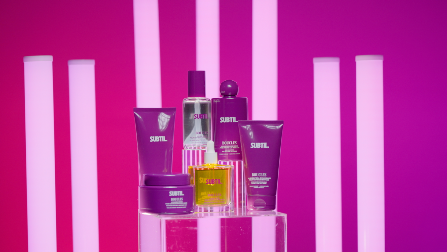 Produits capillaires Subtil photographiés sur un plateau rose