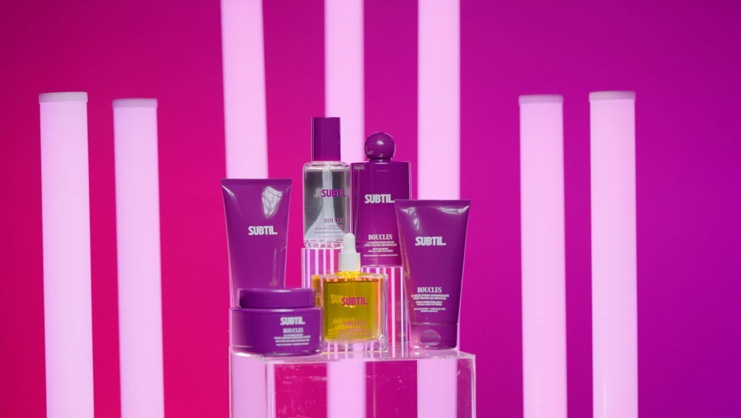 Produits capillaires Subtil photographiés sur un plateau rose